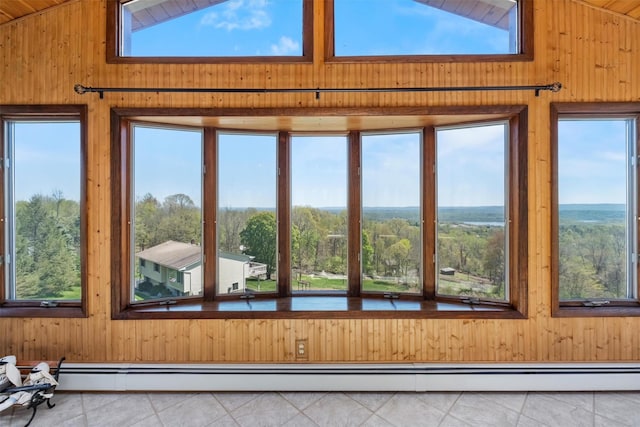 unfurnished sunroom featuring wooden walls, high vaulted ceiling, and tile patterned flooring