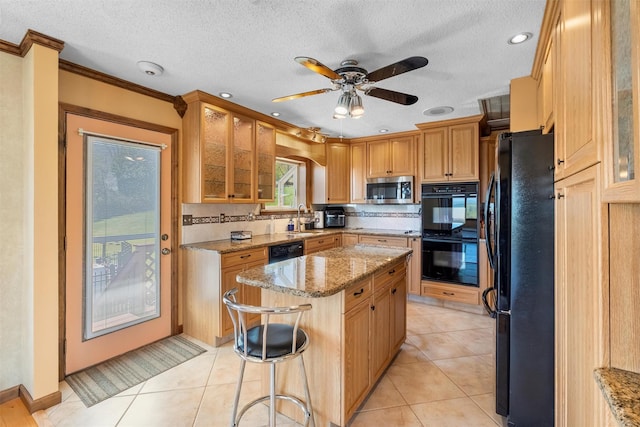 kitchen featuring ornamental molding, light stone countertops, a center island, a textured ceiling, and black appliances
