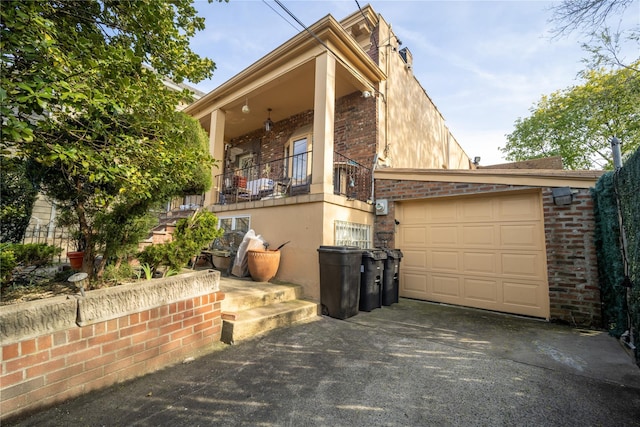 view of front of property featuring brick siding, a garage, and driveway