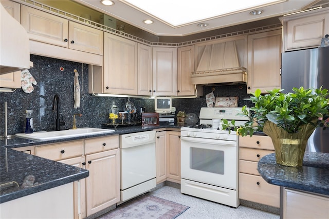 kitchen with custom exhaust hood, white appliances, recessed lighting, a sink, and backsplash