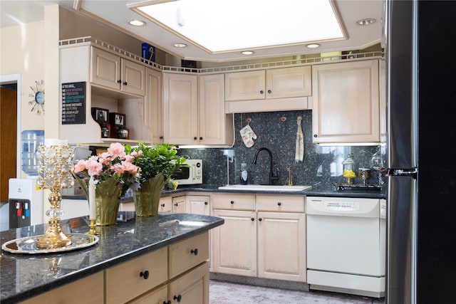 kitchen with tasteful backsplash, a sink, dark stone counters, recessed lighting, and white appliances