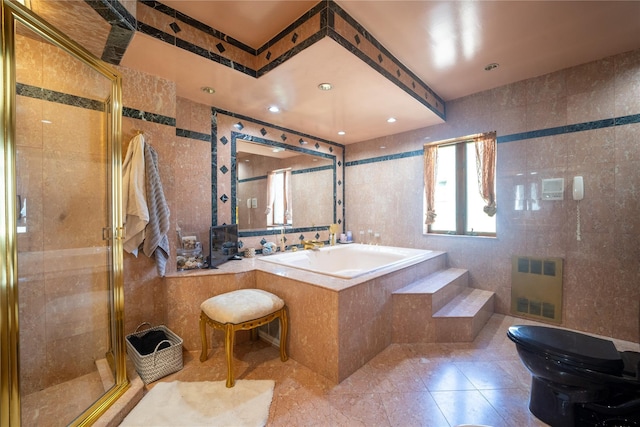 bathroom with tile walls, a shower stall, and a bath