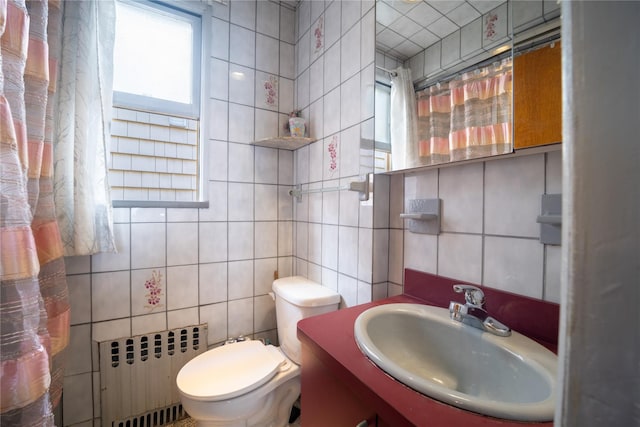 bathroom with a sink, toilet, radiator, tile walls, and decorative backsplash