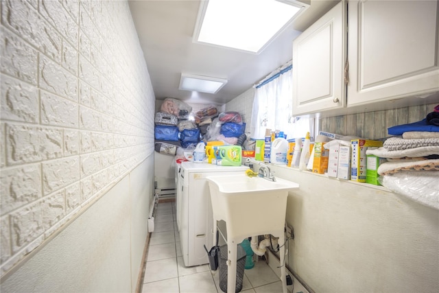 laundry area featuring separate washer and dryer, cabinet space, and light tile patterned flooring