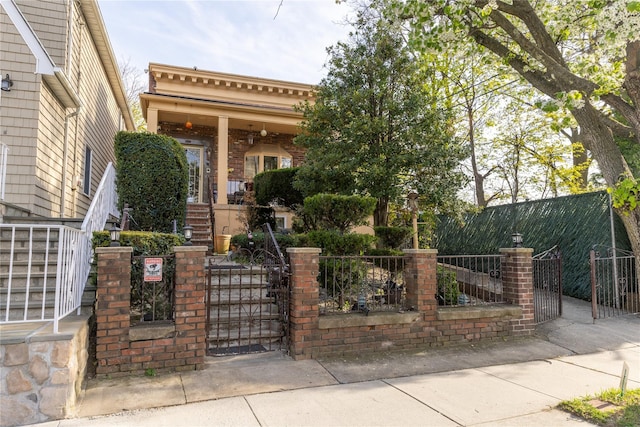 view of front of home with a gate, a fenced front yard, and a porch