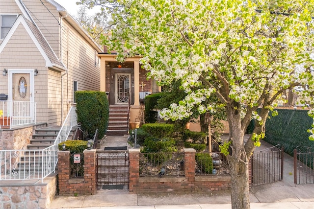 view of front of house featuring a gate, a fenced front yard, and stairway