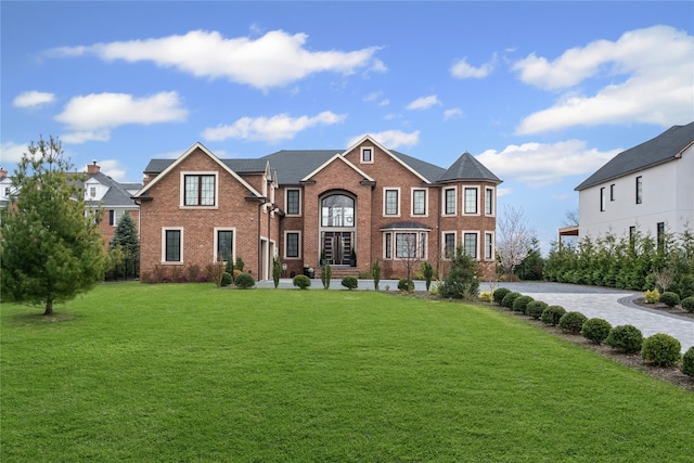 view of front of home featuring a front lawn and brick siding