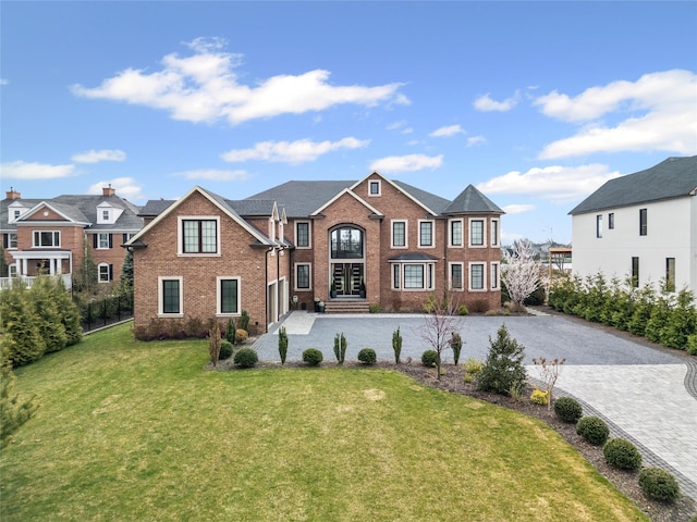 view of front of house featuring brick siding and a front yard
