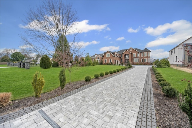 view of front of property with decorative driveway and a front yard