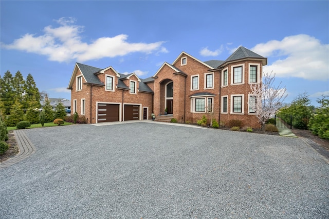 traditional-style house featuring brick siding and gravel driveway