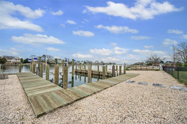dock area featuring fence and a water view