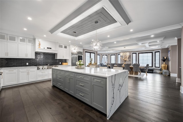 kitchen featuring a center island, gray cabinetry, white cabinets, a notable chandelier, and stainless steel gas stovetop