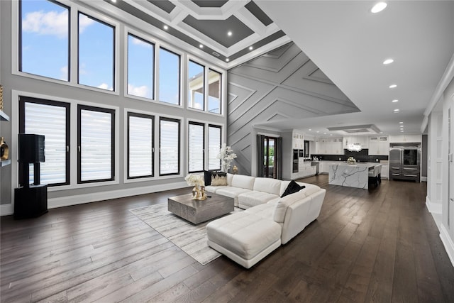 living room featuring dark wood-style flooring, a high ceiling, and recessed lighting