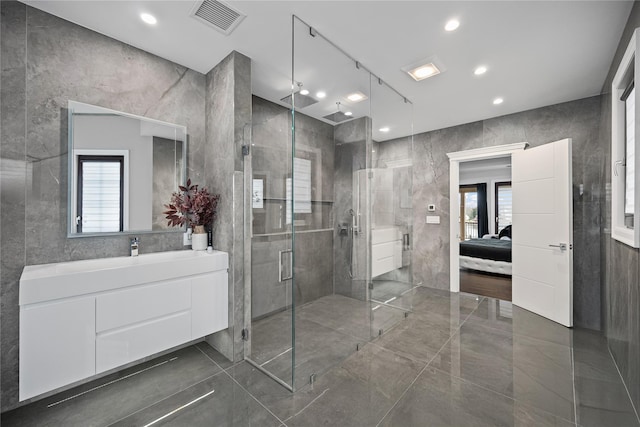 ensuite bathroom with vanity, ensuite bath, tile walls, a shower stall, and visible vents