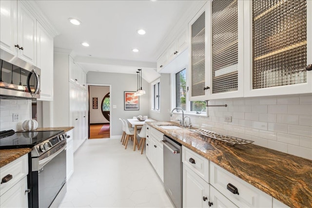 kitchen with appliances with stainless steel finishes, a sink, white cabinetry, glass insert cabinets, and recessed lighting