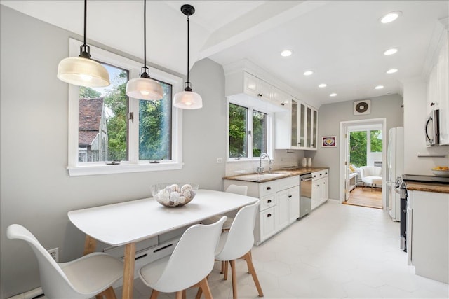 kitchen featuring stainless steel appliances, recessed lighting, white cabinets, glass insert cabinets, and light stone countertops