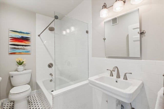bathroom with toilet, a sink, shower / bath combination, and tile patterned floors