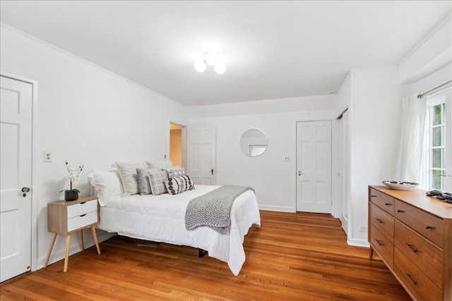bedroom featuring wood finished floors and baseboards