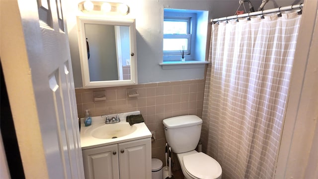 full bath featuring vanity, toilet, a wainscoted wall, tile walls, and curtained shower