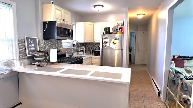 kitchen featuring light tile patterned flooring, stainless steel appliances, a peninsula, tasteful backsplash, and a baseboard heating unit