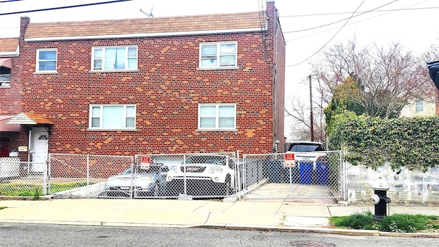 view of front facade featuring a gate, fence private yard, and brick siding