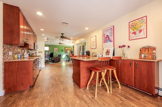 64 Harmon St, Long Beach, NY 11561 - indoor dry bar featuring stainless steel microwave, wood finished floors, ceiling fan, recessed lighting, and decorative backsplash