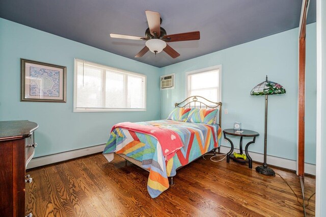 64 Harmon St, Long Beach, NY 11561 - bedroom with a baseboard heating unit, multiple windows, a wall mounted air conditioner, and wood finished floors