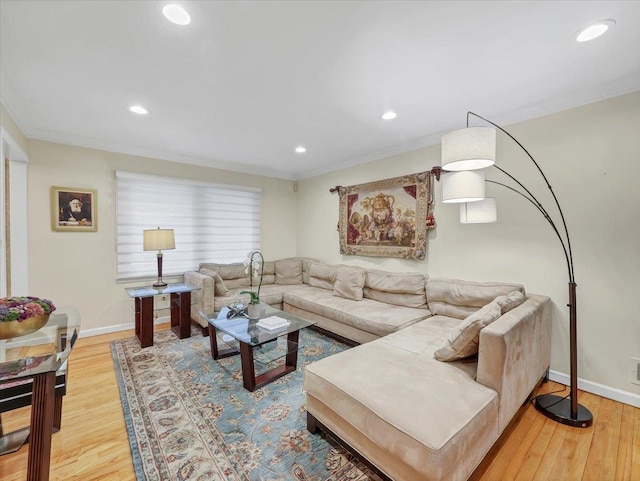 living area with ornamental molding and wood finished floors