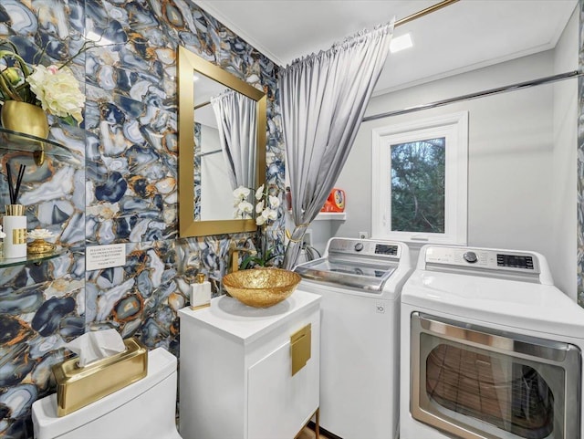 clothes washing area featuring separate washer and dryer and laundry area