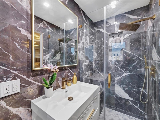 full bath featuring tile walls, a marble finish shower, and vanity
