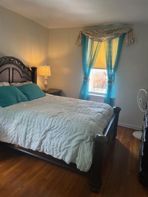 bedroom with baseboards and wood finished floors