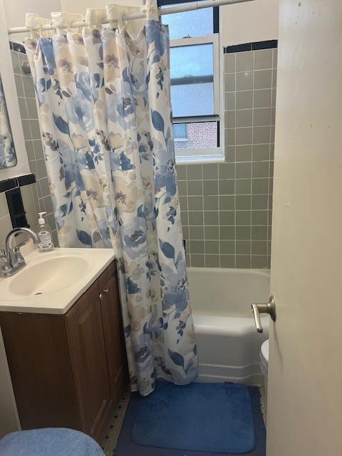 bathroom featuring vanity, shower / tub combo, and toilet