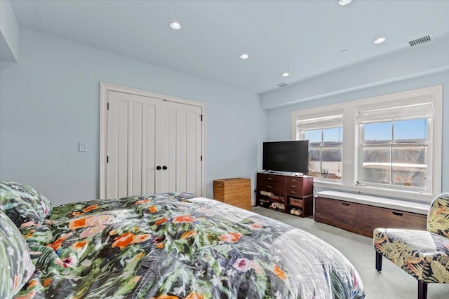 bedroom with light carpet, a closet, recessed lighting, and visible vents