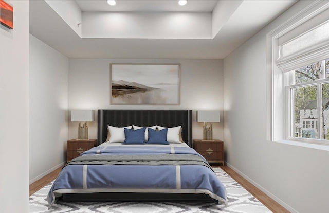 bedroom featuring baseboards, recessed lighting, wood finished floors, and a raised ceiling