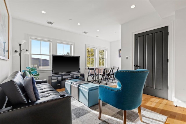 living room featuring recessed lighting, light wood finished floors, and visible vents