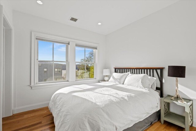 bedroom with visible vents, recessed lighting, baseboards, and wood finished floors