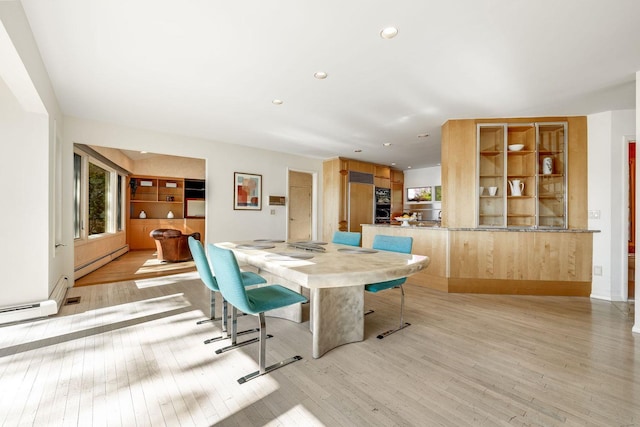 dining space featuring recessed lighting, a baseboard heating unit, a wealth of natural light, and light wood-style floors