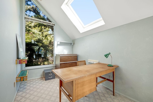office area with carpet floors, baseboards, and vaulted ceiling with skylight