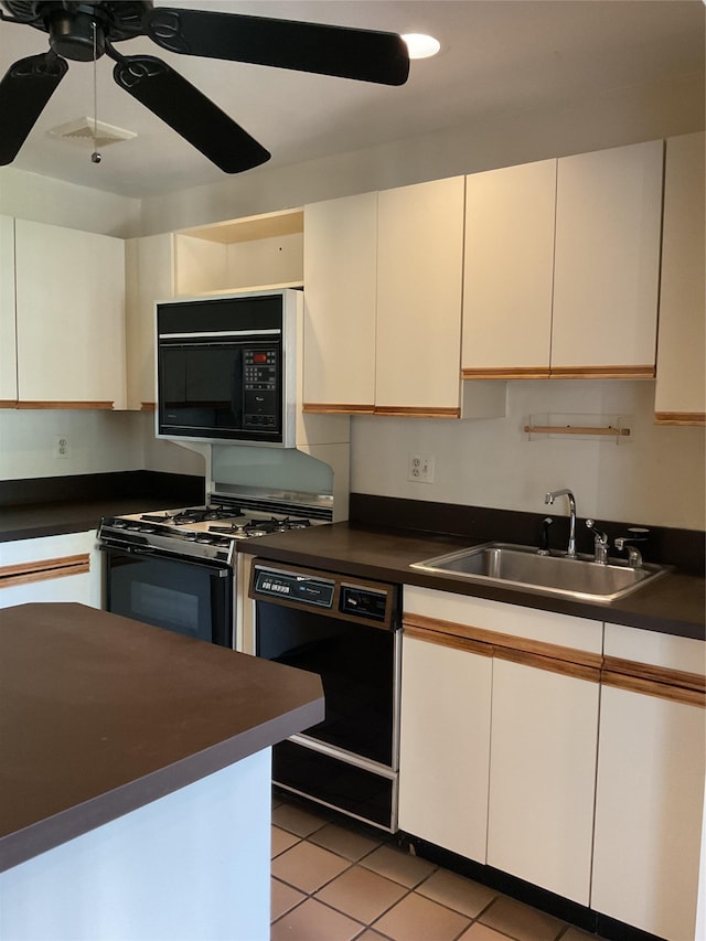 kitchen featuring a ceiling fan, dark countertops, a sink, black appliances, and white cabinetry