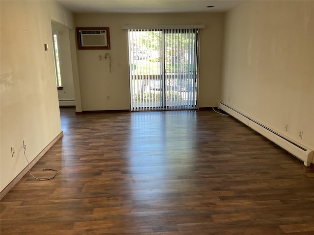 empty room featuring baseboards, a baseboard radiator, dark wood-style flooring, and a wall mounted air conditioner