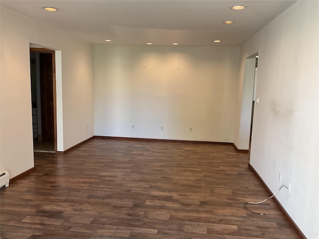 spare room with dark wood-style flooring, recessed lighting, and baseboards
