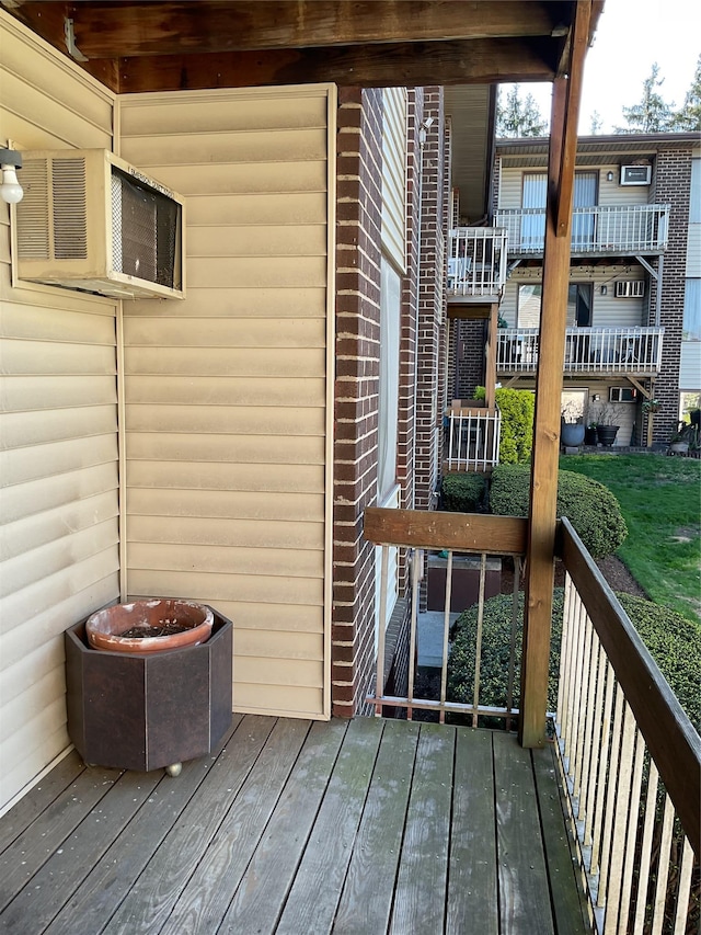 wooden deck featuring an AC wall unit
