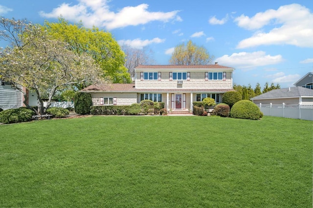 view of front of home with fence and a front lawn