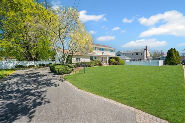 view of front of house featuring a front lawn and fence