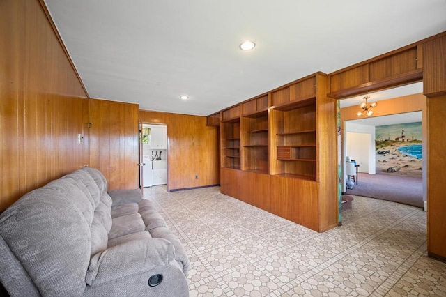 living area featuring wooden walls, an inviting chandelier, and recessed lighting