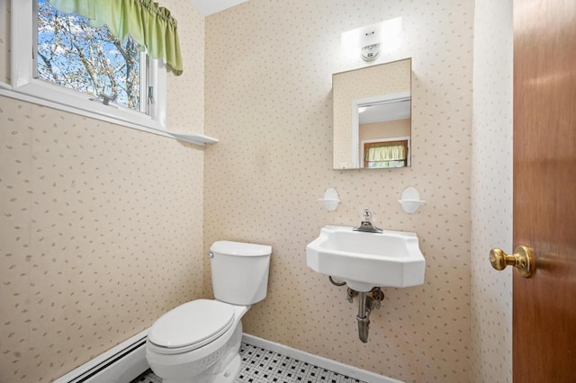 half bath with baseboards, baseboard heating, toilet, and wallpapered walls