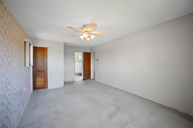 unfurnished bedroom featuring a ceiling fan, a closet, and ensuite bath