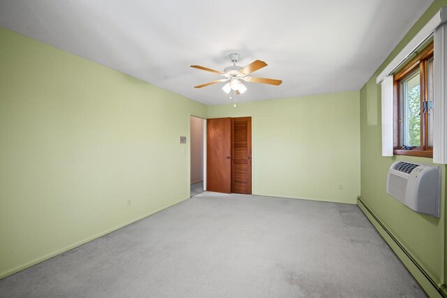 unfurnished bedroom featuring carpet flooring, an AC wall unit, a ceiling fan, a baseboard heating unit, and a closet