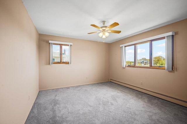 carpeted spare room with baseboards, ceiling fan, a baseboard heating unit, and a wealth of natural light