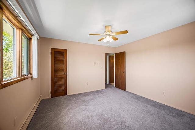 unfurnished bedroom with a ceiling fan, baseboard heating, baseboards, a closet, and carpet